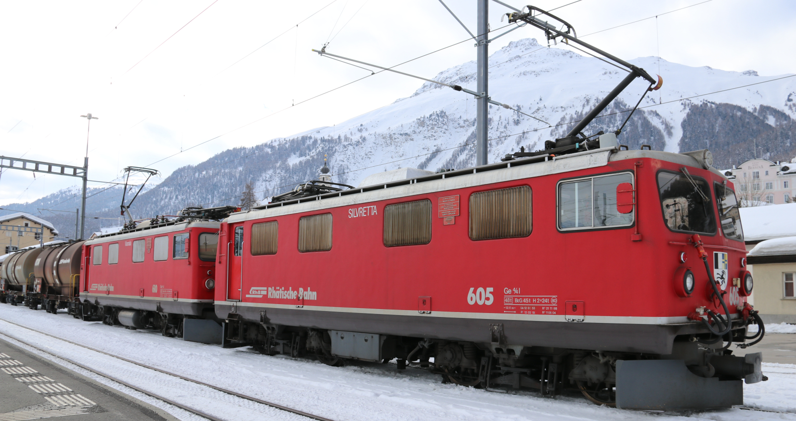 No. 605 and 610 with modern driver's cabs in February 2021 in front of a freight train in Samedan